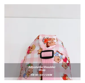 Detail der verstellbaren Schultergurte einer rosa karierten Kindertasche mit Comic-Motiven