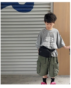 Close-up of kids street style set featuring a grey distressed T-shirt and green cargo shorts