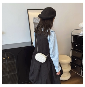 Detailed view of kids white oval quilted crossbody bag with stylish gold chain strap