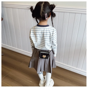 Rear view of child in striped shirt and pleated skirt with heart-shaped chain bag