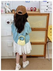 Détail du sac croissant jaune pour enfant avec logo carré et bandoulière chaîne