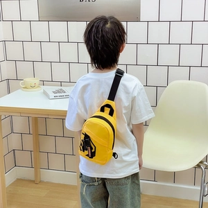 Bright yellow boys' chest bag with adjustable black strap shown in minimalist interior