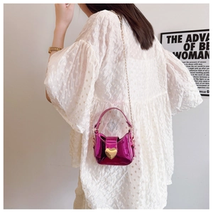 Détail du fermoir cœur rose rouge sur un mini sac à main laser brillant pour filles