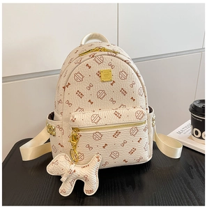 Détail d'un sac à dos en similicuir crème avec imprimés de chats et finitions dorées