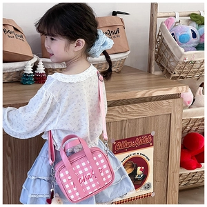 Pink checkered kids crossbody bag with lace accessory worn by child model