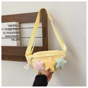 Détail du sac de poitrine pour enfants en toile jaune avec trois étoiles en peluche colorées
