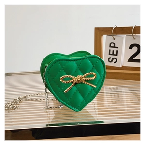 Detail of green heart-shaped girls crossbody bag with quilted pattern and gold bow accent