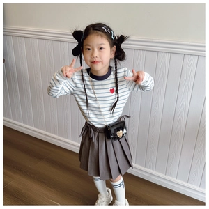 Close-up of heart pattern top and pleated skirt set with a mini heart crossbody bag