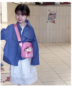 Detailed view of pink plaid kids crossbody bag featuring a cute kitty plush charm