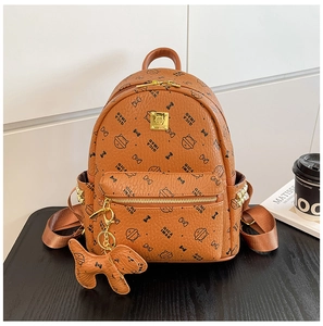 Détail d'un mini sac à dos en cuir caramel avec motif chat et zips dorés élégants