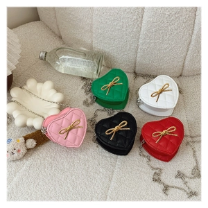 Close-up of heart-shaped quilted bags with gold bow accents in five colors