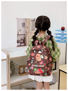 Rear view of child wearing a brown Capybara backpack with cartoon animal patterns