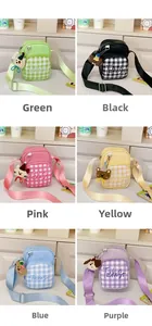 Detail of plaid kids crossbody bag featuring colorful options and plush animal charms