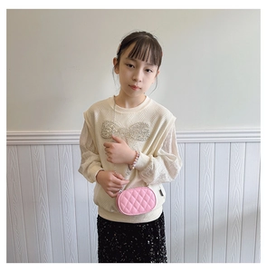 Pink quilted oval mini chain bag paired with a beige sequin bow knit top for kids