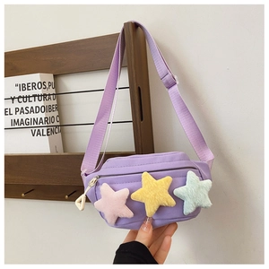 Gros plan d'un sac banane en toile lilas avec trois décorations d'étoiles en peluche