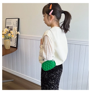 Macro detail of kids bright green quilted chain crossbody bag with stylish embroidery