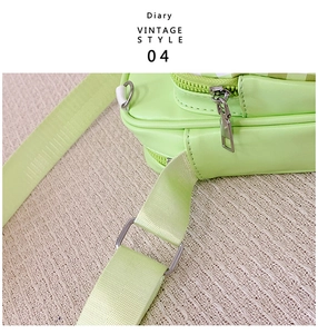 Detail of light green cartoon crossbody bag with adjustable nylon strap and silver buckle