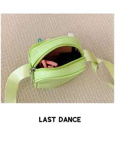 Detail view of neon green mini crossbody bag showing internal storage space and pink glasses