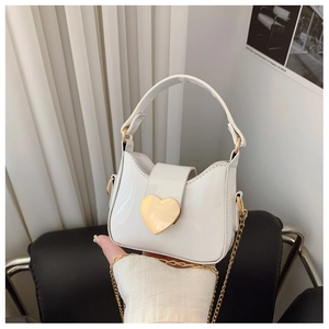 Détail du sac blanc verni pour fille avec un fermoir en métal doré brillant en forme de cœur