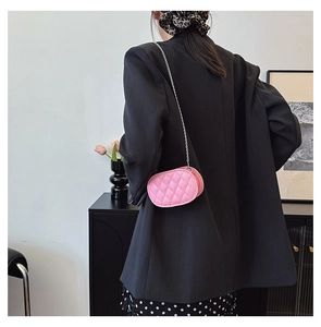 Detailed view of a pink quilted chain crossbody bag for kids shown in lifestyle setting