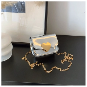 Detail of silver mirror mini bag featuring a gold heart lock and metallic chain strap