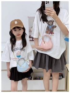Mini sac demi-lune à chaîne porté par parent et enfant en coloris rose et bleu clair