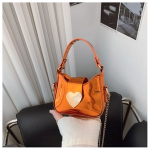 Détail du mini sac orange laser brillant avec boucle cœur dorée et bandoulière chaîne