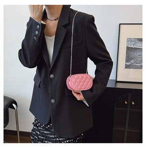 Macro detail of a pink quilted mini chain bag with classic silver metal strap on a model