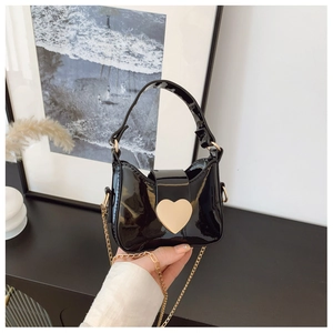 Détail du sac à main pour enfants en cuir verni noir brillant avec boucle cœur dorée