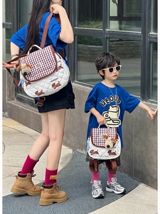 Outdoor shot of matching parent-child puppy backpacks with white quilted fabric and charms