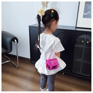 Détail du petit sac bandoulière rose laser pour fille avec noeud doré et chaîne