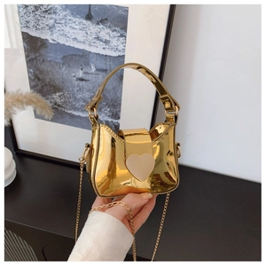 Vue détaillée d'un mini sac doré métallisé avec un fermoir magnétique élégant en forme de cœur
