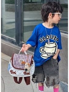 Detail of white quilted leather kids backpack with brown check trim and plush dog charm