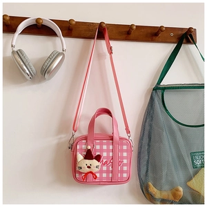 Pink and white checkered mini bag with a cute cat pendant hanging on a wooden hook