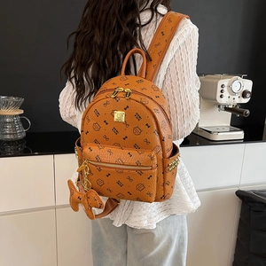 Sac à dos marron avec imprimé chat, fermetures dorées et pendentif nœud papillon