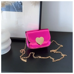 Detail of fuchsia metallic mini bag featuring a large gold heart buckle and chain strap