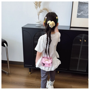 Détail du sac bandoulière rose métallisé pour filles avec nœud doré et bandoulière