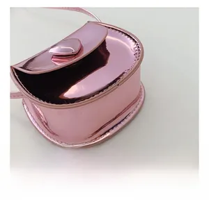 Detail showing the neat stitching and shiny pink heart buckle on a mini leather bag