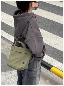 Detail of green canvas crossbody bag for kids styled in Japanese street fashion