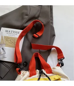Détail de la bandoulière orange réglable et fermeture à cordon du sac seau en toile