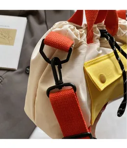 Détail du sac seau en nylon avec bandoulière orange et fermeture par cordon de serrage