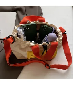 Sac seau en toile montrant sa grande capacité avec téléphone, parapluie et cosmétiques