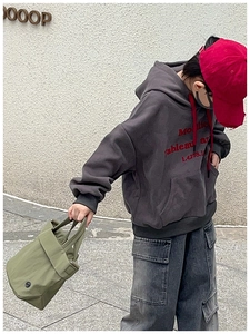 Detail of child streetwear set with dark grey hoodie, red drawstrings and cargo denim pants