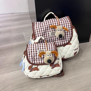 Close-up of cute dog plush pendant on checkered brown and white quilted kids backpack