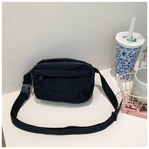 Detail of black canvas messenger bag featuring multiple zipper pockets and adjustable strap