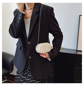 Detail of white quilted leather chain bag showing elegant oval shape and metal strap