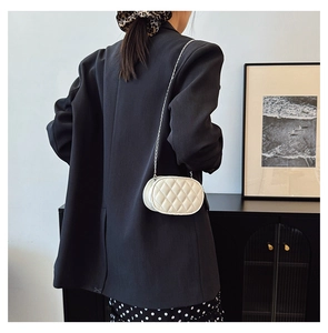Detail of a beige quilted chain shoulder bag for kids with elegant diamond stitching