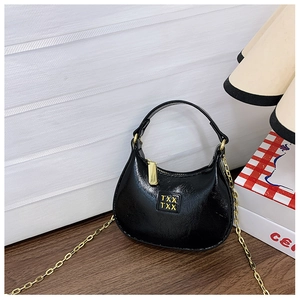 Détail du mini sac noir en similicuir avec bandoulière chaîne dorée et logo TXX TXX