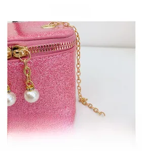 Detailed macro view of pink sequin fabric with gold chain and pearl zipper charms