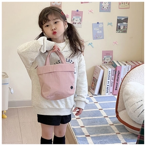 Detailed view of pink canvas tote bag for children with handle and minimalist button